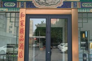 A hotel entrance with a glass door and a sign indicating it is a hotel. - Hejia Inn (Beijing Tsinghua) (Beijing)