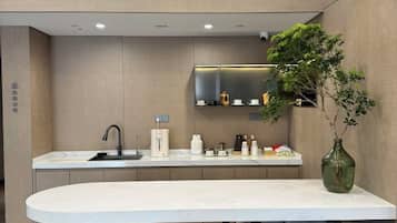 Cozinha moderna com ilha central, eletrodomésticos de aço inoxidável e um vaso de planta.