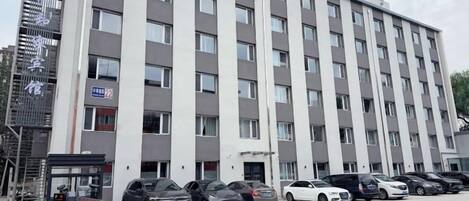 A multi-story hotel with a parking lot in front.