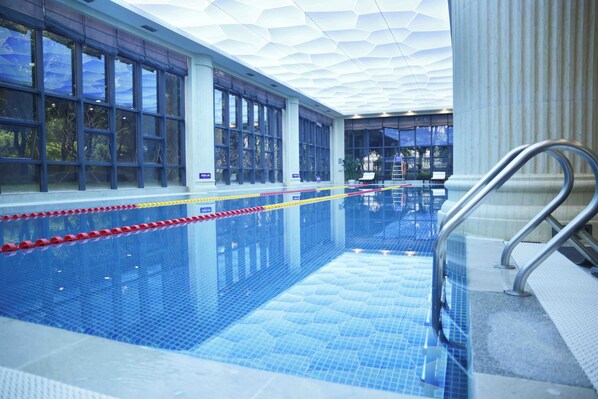 An indoor swimming pool with clear water, a tiled floor, and a glass barrier. - Fliport Garden Hotel Xiamen (Xiamen)