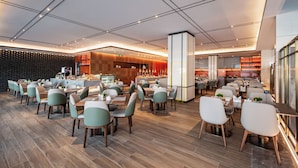 Un restaurante moderno con una barra central, varias mesas y sillas.