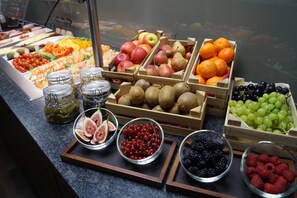 A variety of fresh fruits and vegetables displayed in wooden crates and bowls. - Hotel am Garnmarkt (Goetzis)