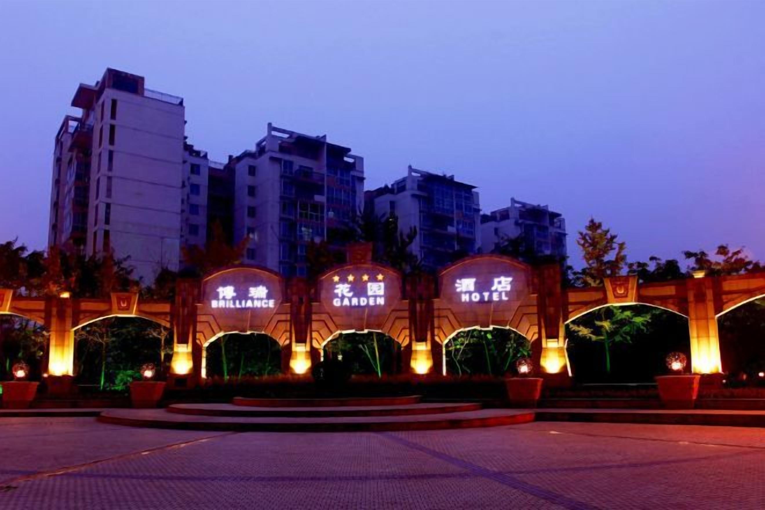 A hotel entrance with illuminated arches and a paved plaza.