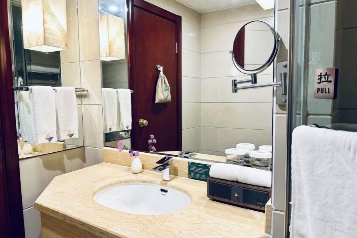 A bathroom with a sink, mirror, towel rack, and a 'PULL' sign.