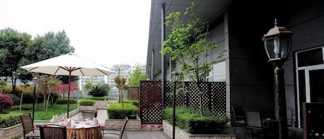 Un patio exterior con una mesa y sillas, un farol y una valla.