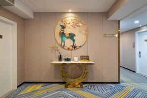A reception area with a wall-mounted artwork of a deer, a reception desk, and a carpeted floor.