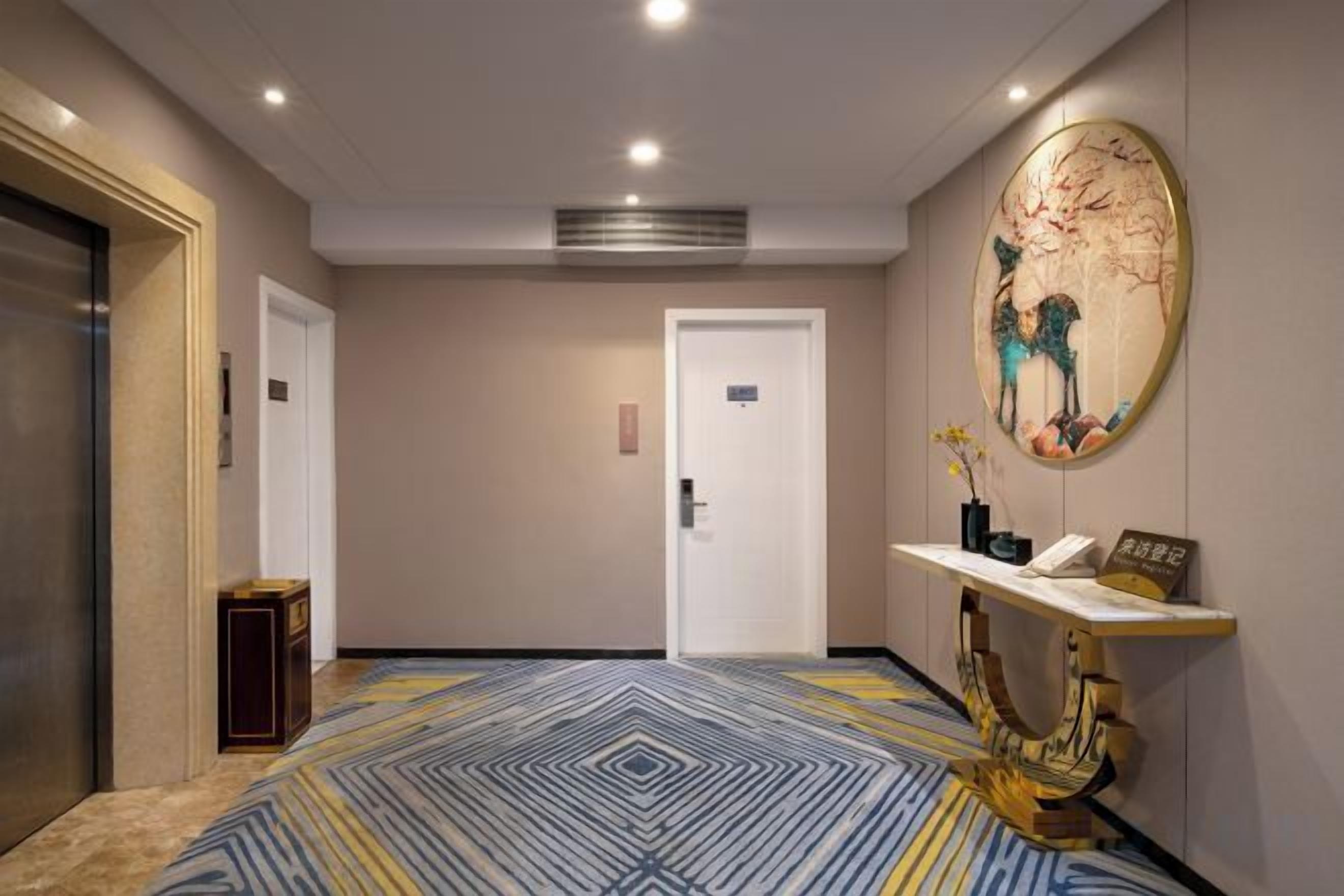 Un hall d’hôtel avec un comptoir d’accueil, une porte et un tapis à motifs.