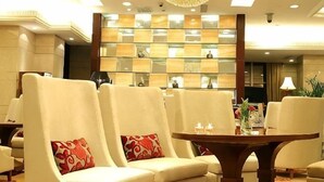 A hotel lobby with plush seating, a chandelier, a reception desk, and a decorative wall. - Jinyan Hotel (SHANGHAI)