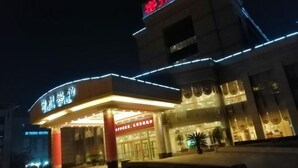 A hotel entrance with illuminated signage and a modern architectural design. - Mizhou Hotel (ZHUCHENG)