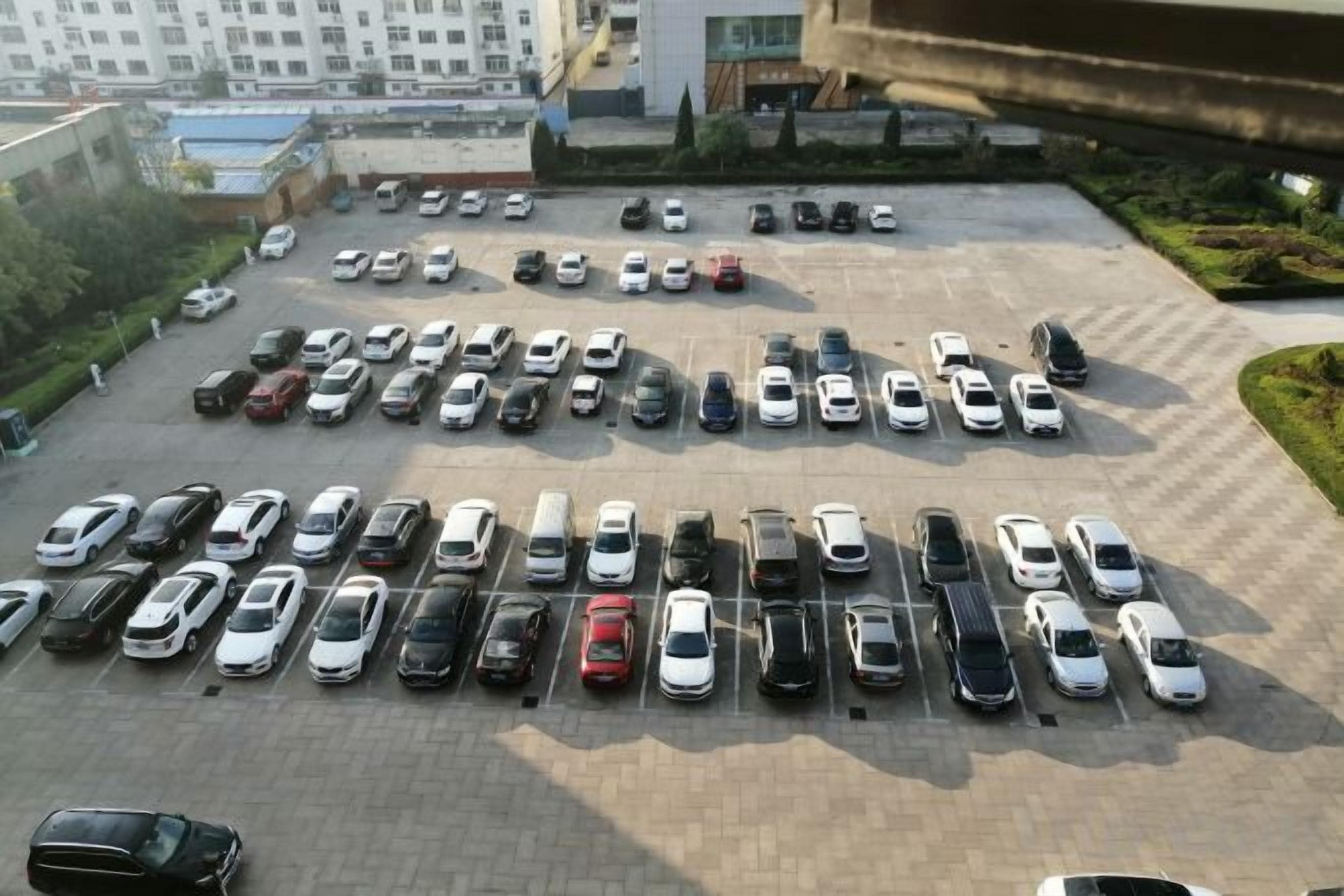Un estacionamiento con varias filas de coches aparcados.