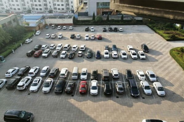 Un estacionamiento con varias filas de coches aparcados.