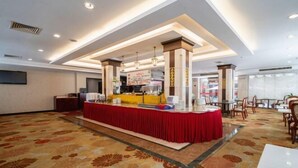 Eine Hotelhalle mit einer Rezeption, einem gemusterten Teppich und einem modernen Deckenstil.