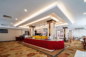 A hotel lobby with a reception desk, a buffet area, and a seating area. - Royal Prince Hotel (Quanzhou)
