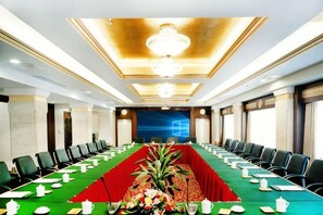 A conference room with a long table, chairs, and a chandelier. - Royal Prince Hotel (Quanzhou)