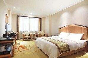 A hotel room with a bed, a desk, a chair, and a television. - Royal Prince Hotel (Quanzhou)