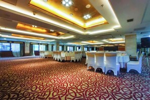 A banquet hall with tables set for events, a patterned carpet, and a modern ceiling design. - Royal Prince Hotel (Quanzhou)