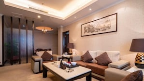 Ein modernes Wohnzimmer mit einer Couch, Sesseln, einem Couchtisch und einer Lampe.