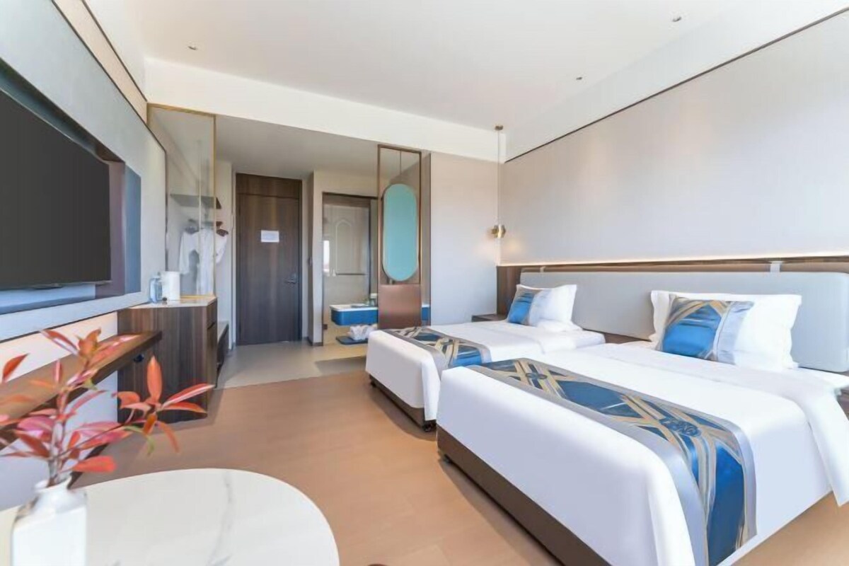 Een moderne hotelkamer met een groot bed, een bureau, een stoel en een televisie.
