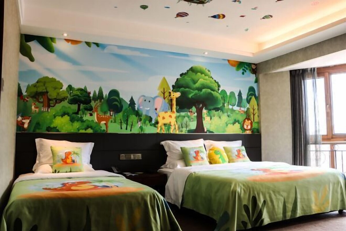 Een kamer met twee bedden, een muurschildering en een raam.