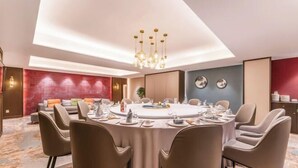 A modern dining room with a round table set for six, surrounded by six chairs. - Tarshan Hotel (WEIHAI)
