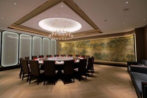 A conference room with a round table, chairs, and a chandelier. - Beijing Henan Business Hotel (Beijing)