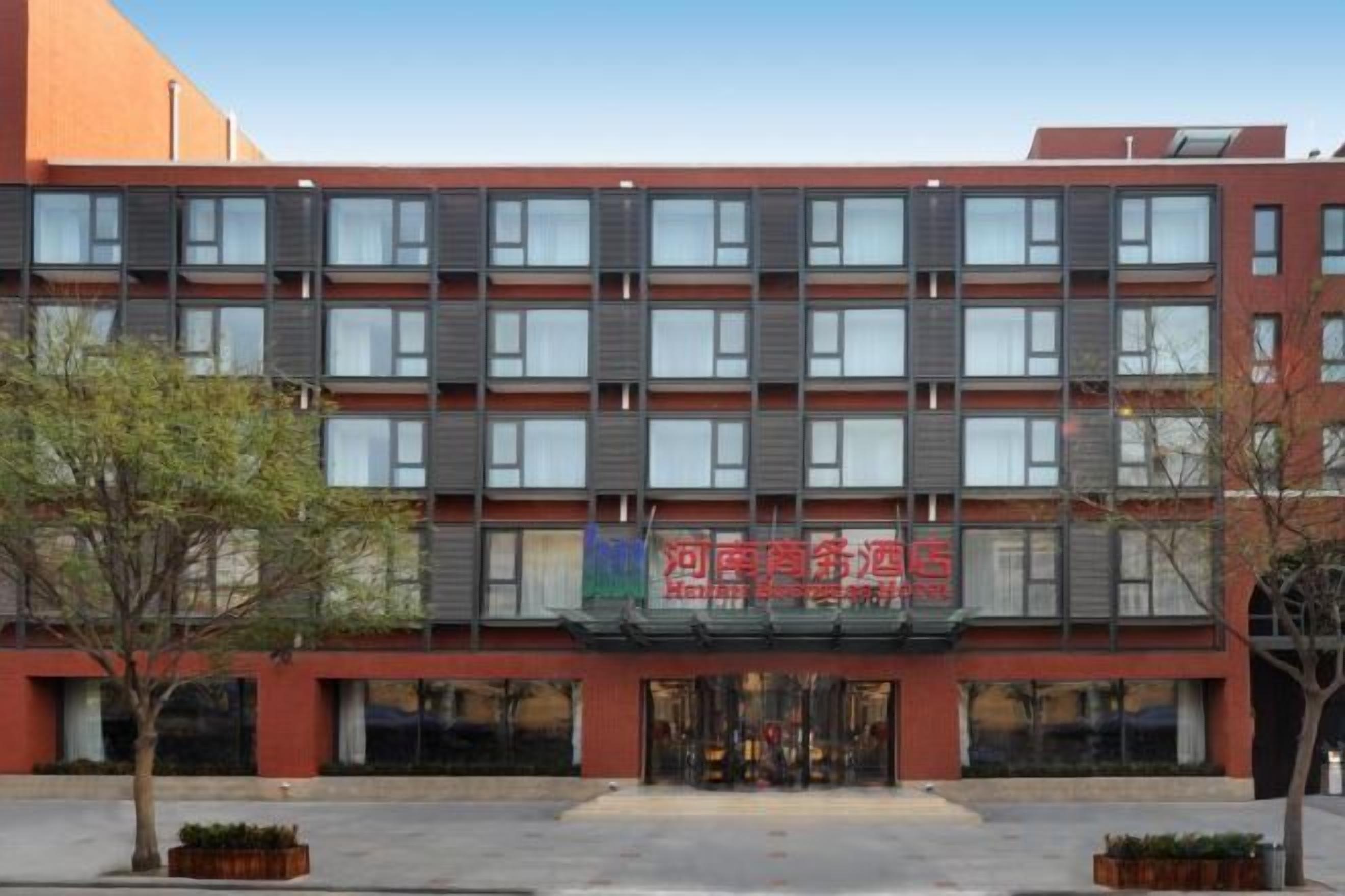 Un hôtel à plusieurs étages, doté d’une façade rouge et d’une entrée centrale.