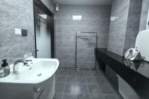 A modern bathroom with a sink, mirror, and towel rack. - Beijing Henan Business Hotel (Beijing)