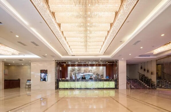 A spacious lobby with a marble reception desk, a large chandelier, and a staircase. - Shenzhen Lotus Hotel (SHENZHEN)