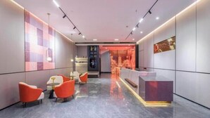 A modern hotel lobby with a reception desk, seating area, and decorative wall panels. - Nanyuan Ejiaplus Hotel (Ninghai Xizi International) (NINGHAI)
