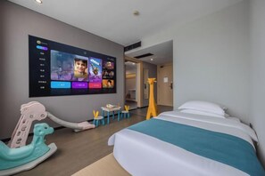 A hotel room with a bed, a television mounted on the wall, a small table with a chair, and a toy horse. - Nanyuan Ejiaplus Hotel (Ninghai Xizi International) (NINGHAI)