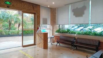 A reception area with a bench, a counter, and a view of parked cars through a window.