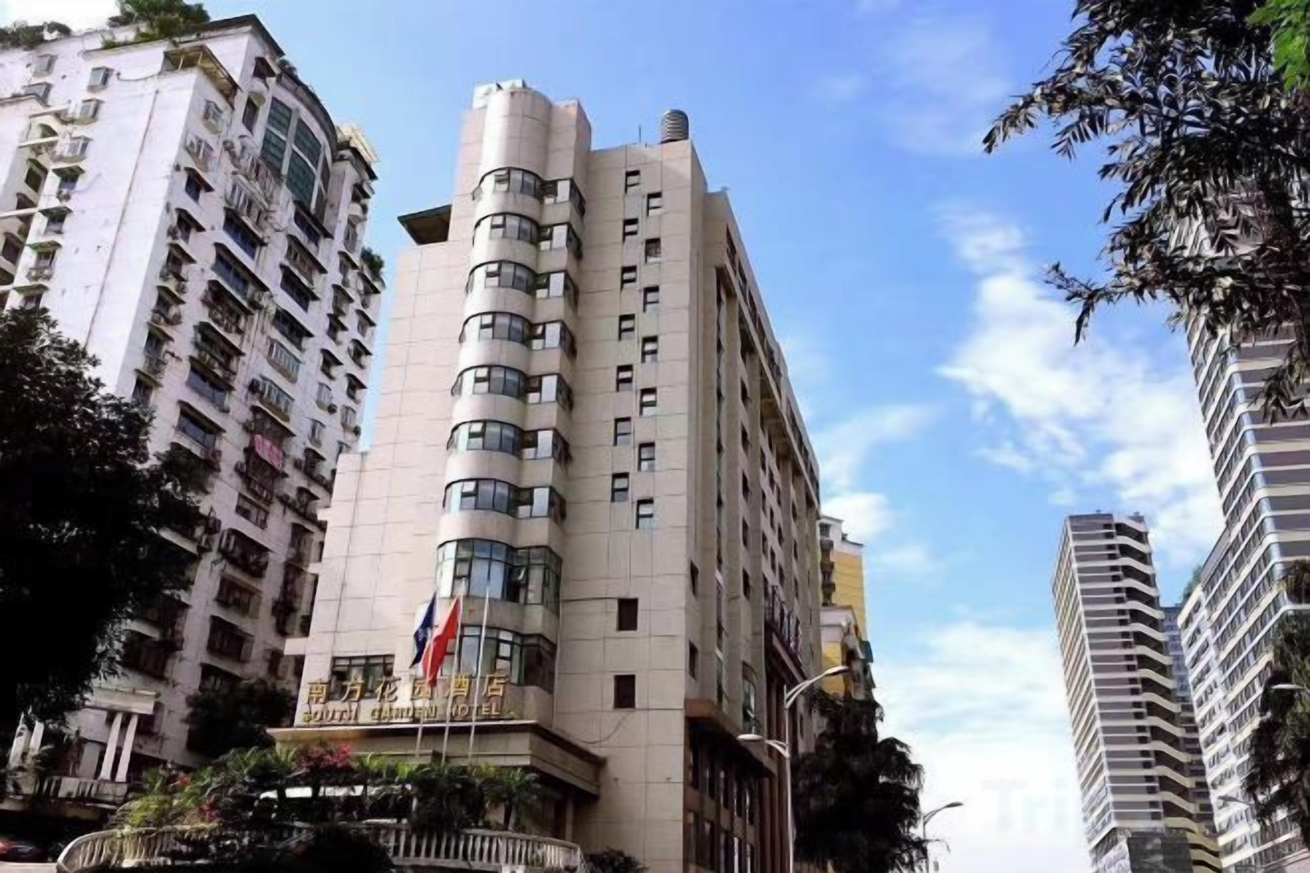 A multi-story hotel with a curved facade, multiple balconies, and a flag on the top.