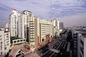 A multi-story hotel with a central courtyard, surrounded by high-rise buildings.