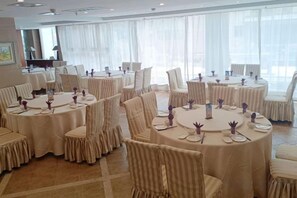 A conference room with round tables and chairs, large windows with sheer curtains, and a carpeted floor. - South Garden Hotel (Chongqing)
