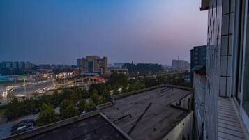A cityscape at dusk with buildings and a parking lot.