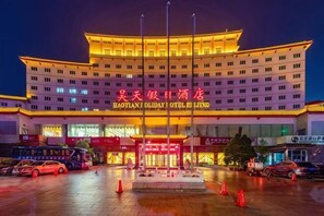 A hotel with a large entrance, multiple floors, and a prominent sign. - Haotian Holiday Hotel Beijing (Beijing)