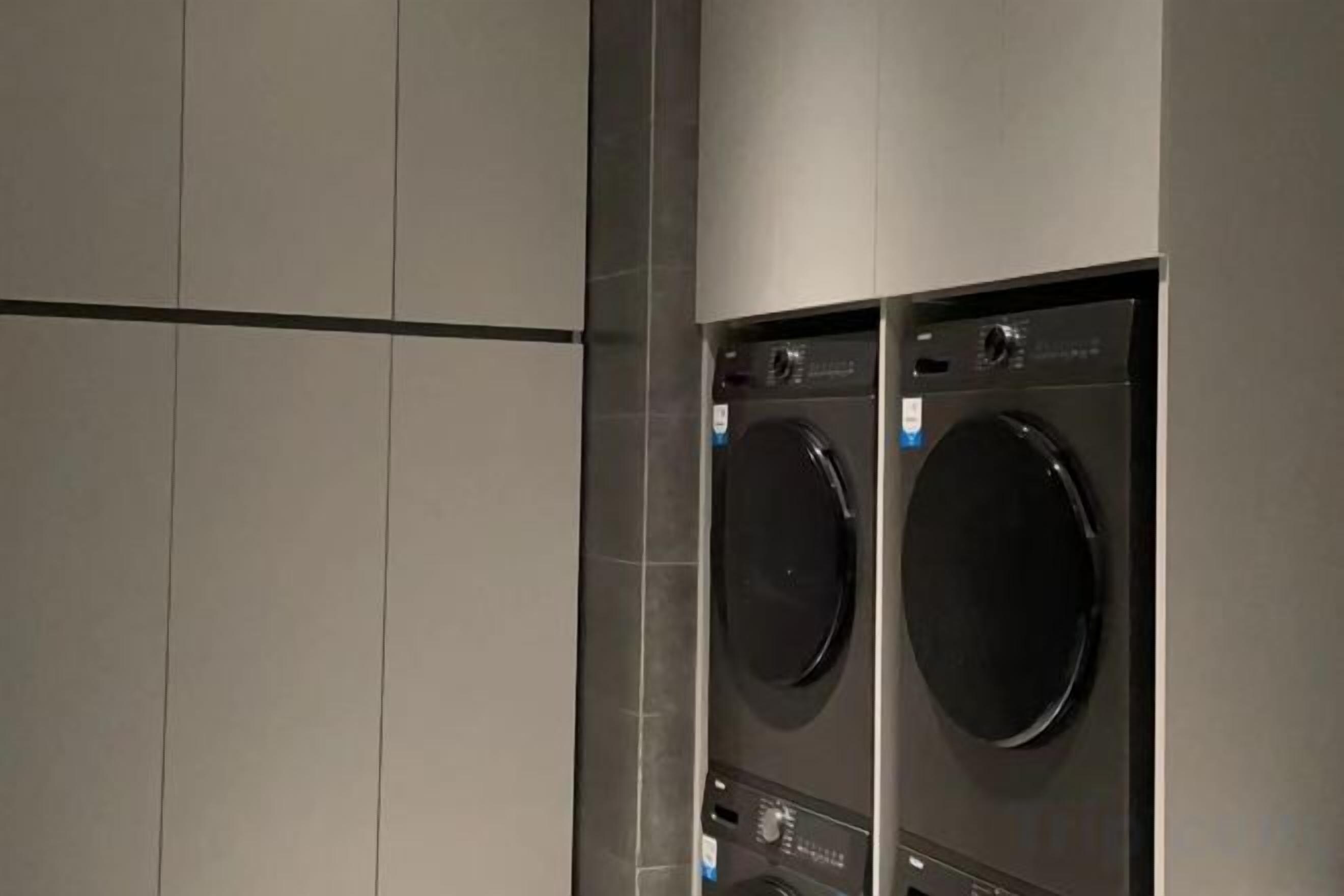 A laundry room with two stacked washing machines.