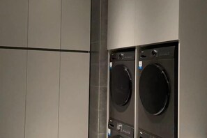 A laundry room with two stacked washing machines. - Hangzhou Junhu International Hotel (HANGZHOU)