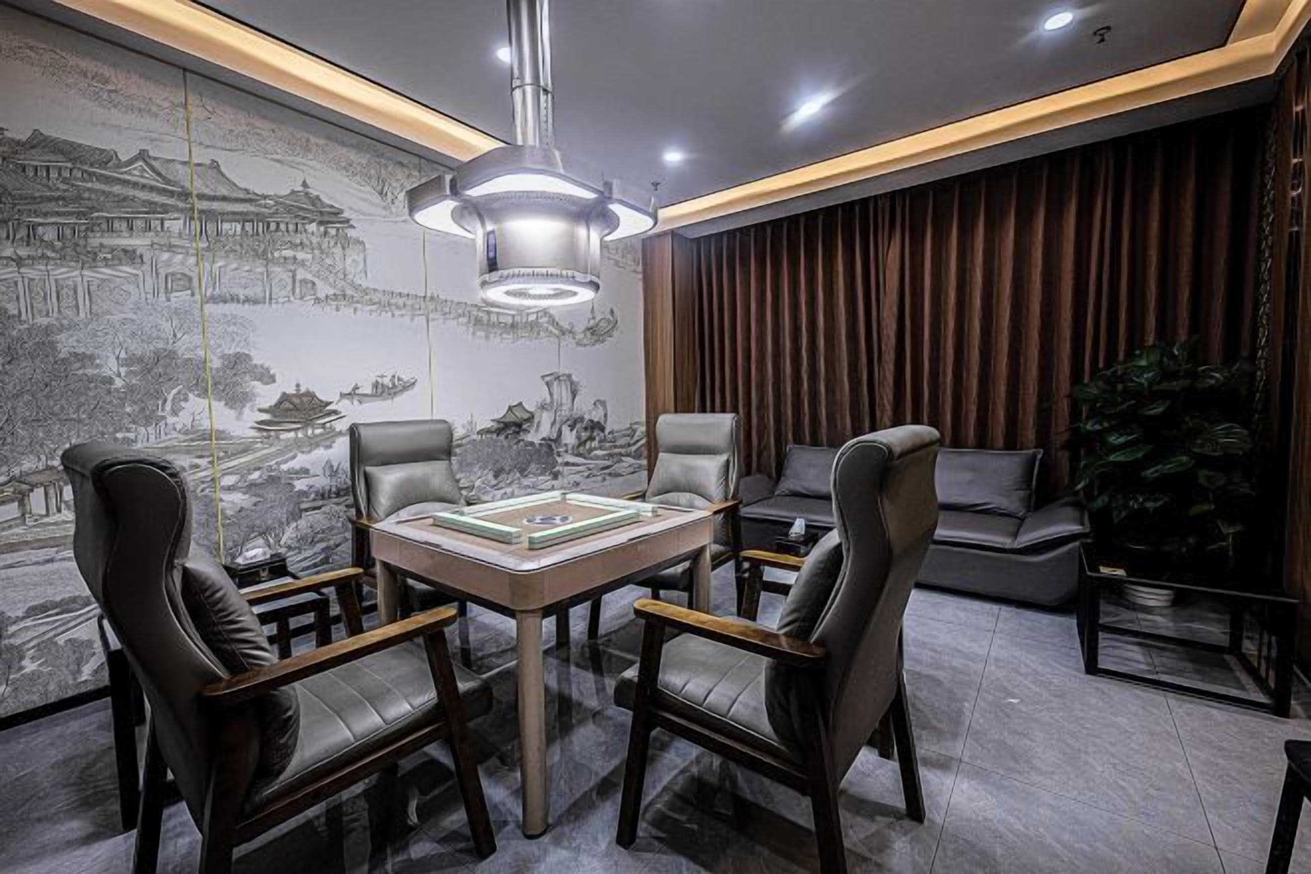 A modern room with a dining table, four chairs, a large wall mural, and a hanging light fixture.