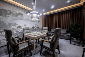 Ein modernes Zimmer mit Esstisch, vier Stühlen, einer großen Wandmalerei und einer Hängeleuchte.