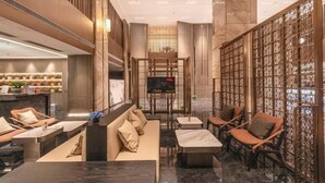 Un intérieur moderne comprenant un coin salon, un téléviseur et un paravent décoratif.