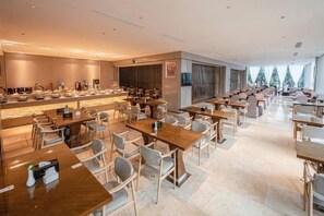 A modern hotel lobby with a long counter, multiple seating areas, and large windows. - Hangzhou Junhu International Hotel (HANGZHOU)