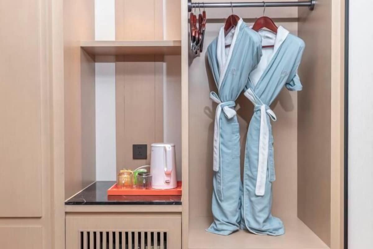 Une salle de bain équipée d’un porte-serviettes, d’un lavabo et d’une machine à café.