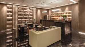 Eine moderne Hotelhalle mit Sitzgelegenheit, einer Rezeption und einem Gepäckausstellungsbereich.
