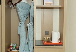Une chambre d’hôtel équipée d’un mini-bar, d’une machine à café et d’une bouteille de soda.