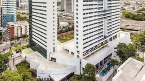 Un edificio de gran altura con diseño moderno, que presenta un atrio central y varios pisos.