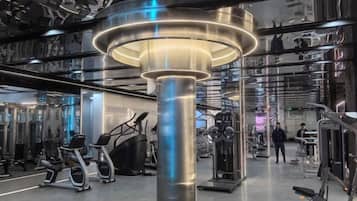 Uma academia moderna com equipamentos de ginástica e um lustre central.