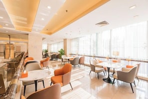A hotel lobby with a marble reception desk, multiple seating areas with tables and chairs, and large windows providing natural light. - Dongyang Building (Dongyang Center Branch) (Dongyang)