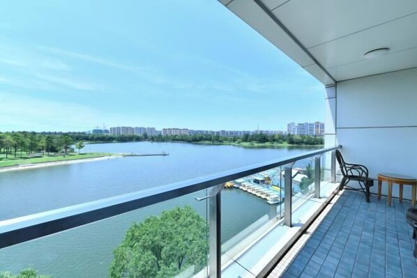 A balcony with a view of a river and distant buildings. - Meilan Lakeside Conference Center Hotel (Shanghai)