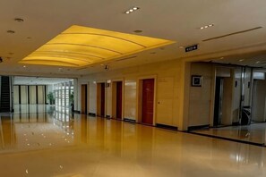 A spacious hotel lobby with a polished floor, a modern ceiling light fixture, and a visible elevator. - Meilan Lakeside Conference Center Hotel (Shanghai)